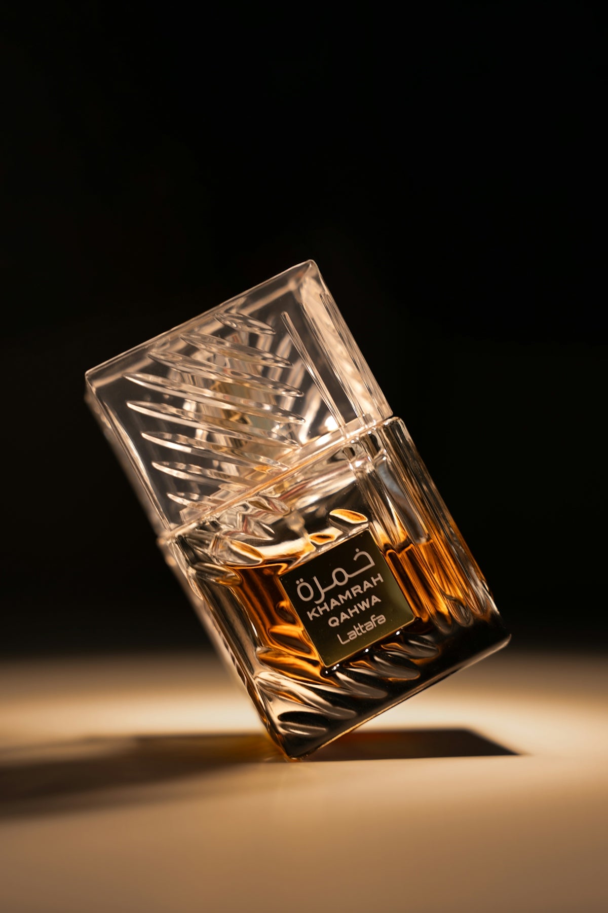 A clear glass perfume bottle with amber liquid.