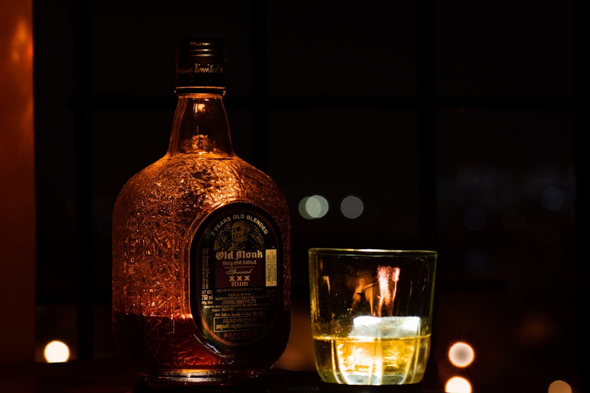 jack daniels old no 7 tennessee whiskey bottle beside clear drinking glass with brown liquid